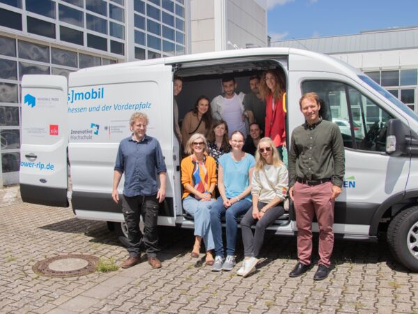 Das EMPOWER-Kernteam im und vor dem Transfermobil bei einem Besuch an der Technischen Hochschule in Bingen (Bild: Milena Buck | TH Bingen)